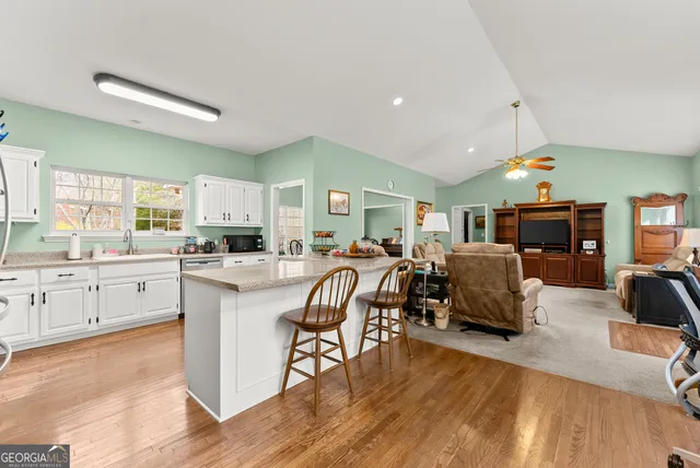 a large white kitchen with lots of counter space dining table and chairs
