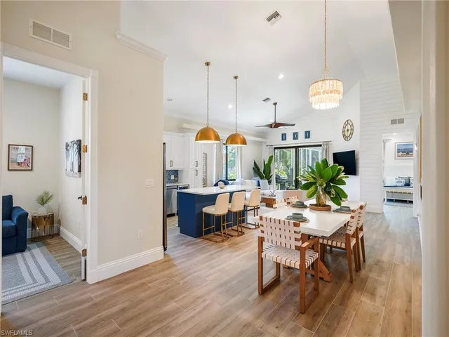 a kitchen with a table chairs and white cabinets