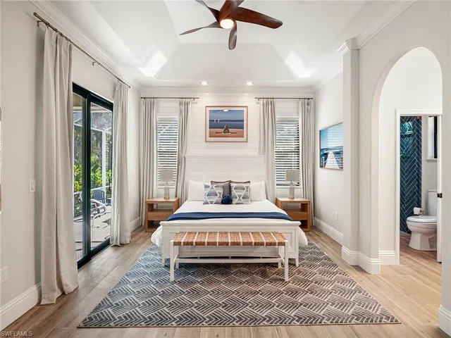 a bedroom with a large bed and a chandelier