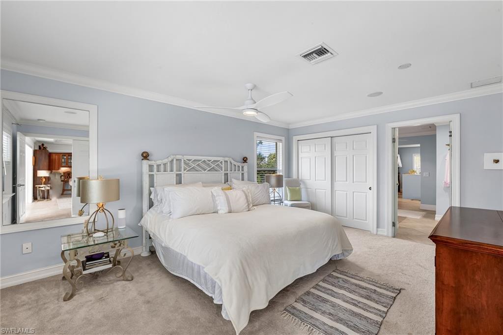 1904 Countess Court Naples, FL 34110 - Photo 15 of 33 a bedroom with a bed a mirror and desk