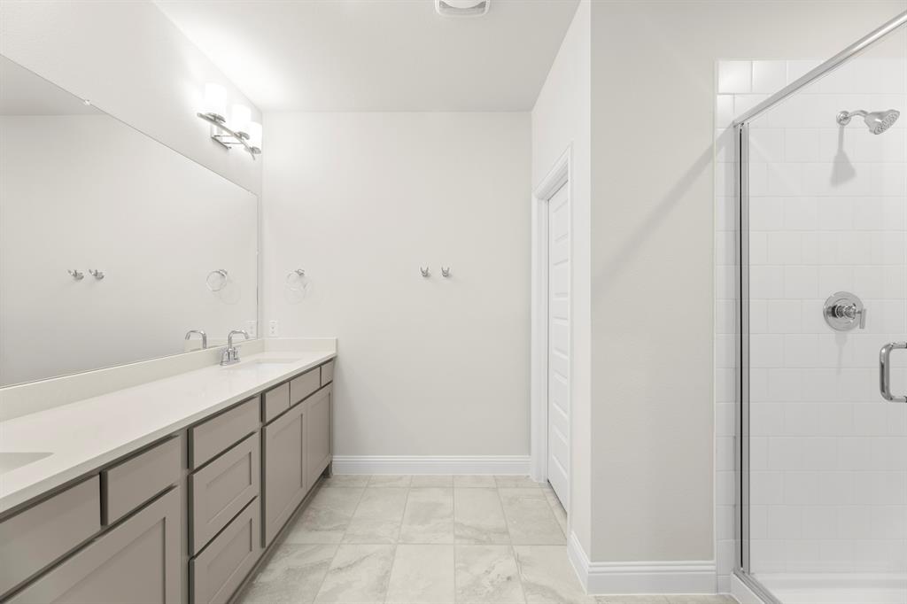 3916 Keya Drive Prosper, TX 75078 - Photo 22 of 28 a bathroom with a double vanity sink a and a mirror