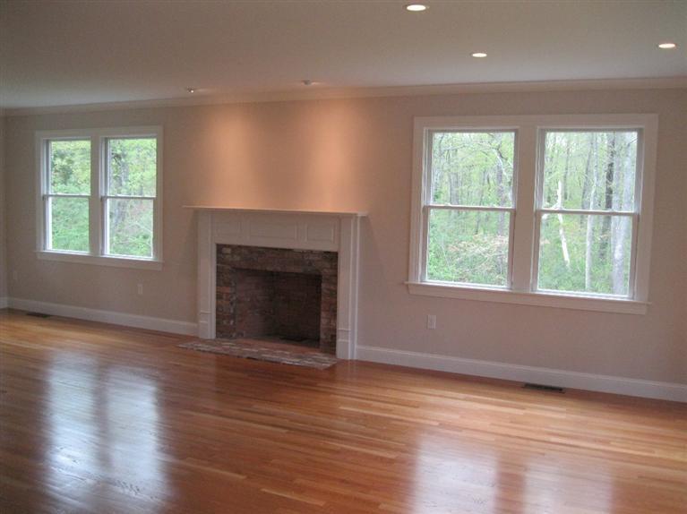 26 Oliver Snow Road Harwich Port, MA 02646 - Photo 4 of 33 an empty room with wooden floor fireplace and windows