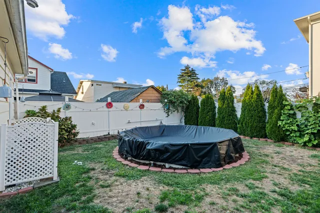 a view of a backyard with brick wall and potted plants