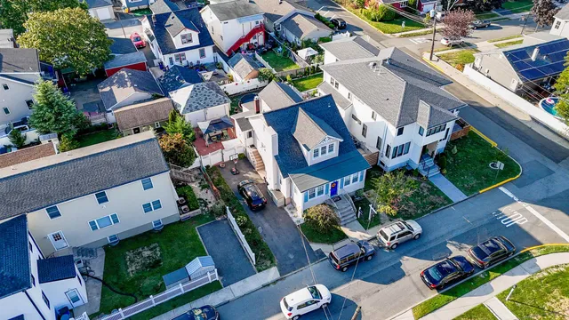 an aerial view of a house with a yard potted plants and large trees