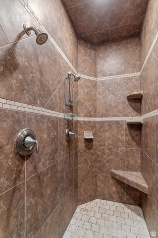 5702 950 North Ogden, UT 84404 - Photo 29 of 36 Tiled shower enclosure featuring dual shower heads, a built-in corner bench, and integrated corner shelving