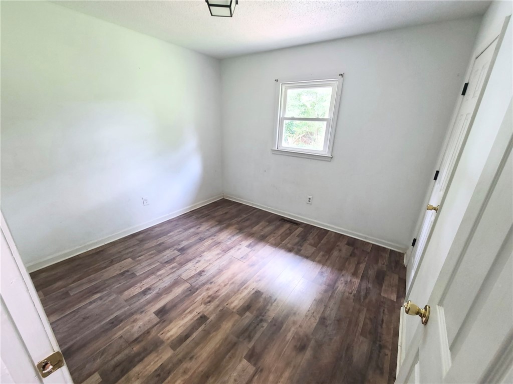 110 Ridgemont Court Greenwood, SC 29649 - Photo 9 of 14 Well-lit room features new plank flooring, offering versatile living options.