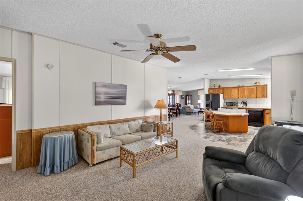 3211 Wekiva Road Tavares, FL 32778 - Photo 13 of 39 a living room with furniture kitchen view and a chandelier