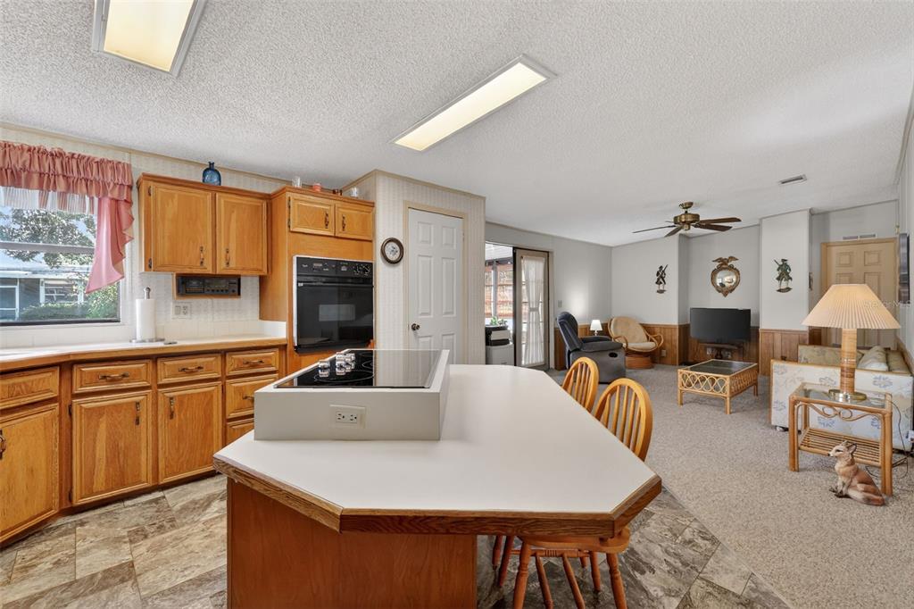 3211 Wekiva Road Tavares, FL 32778 - Photo 16 of 39 a large kitchen with cabinets a sink dishwasher a dining table and chairs with wooden floor