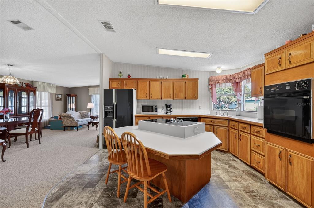 3211 Wekiva Road Tavares, FL 32778 - Photo 19 of 39 a kitchen with stainless steel appliances granite countertop a table chairs sink refrigerator and microwave