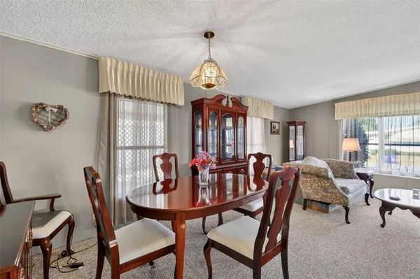 a dining room with furniture a chandelier and window