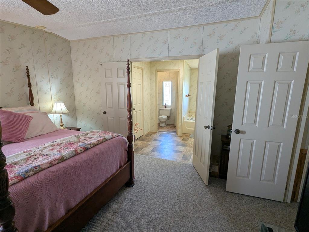 3211 Wekiva Road Tavares, FL 32778 - Photo 24 of 39 a bedroom with a bed and a mirror