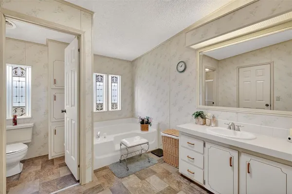 a spacious bathroom with a double vanity sink a mirror and a bathtub