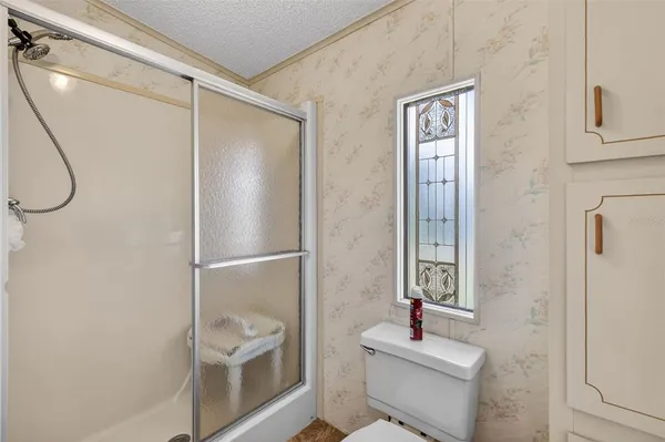 a bathroom with a shower sink vanity and toilet