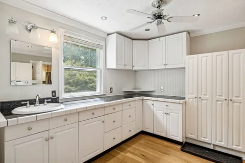 a kitchen with a sink window and cabinets