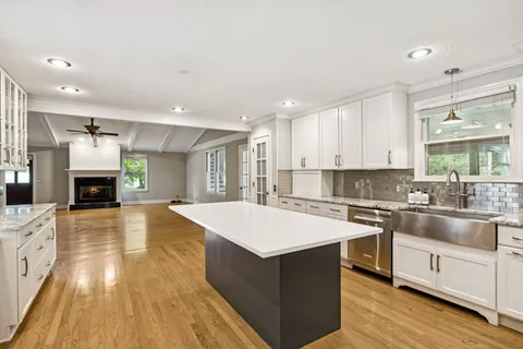 a large kitchen with stainless steel appliances kitchen island a large counter top and a stove