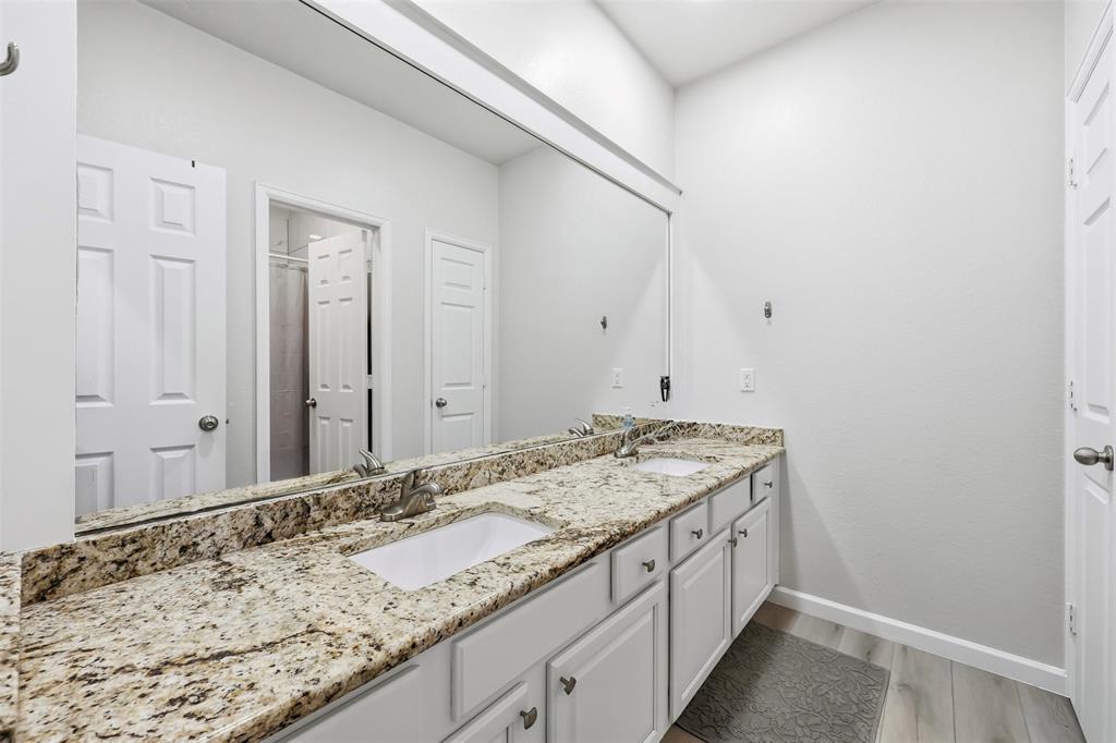 1801 Rim Rock Trail Mansfield, TX 76063 - Photo 23 of 40 a bathroom with a granite countertop sink and a wooden floor