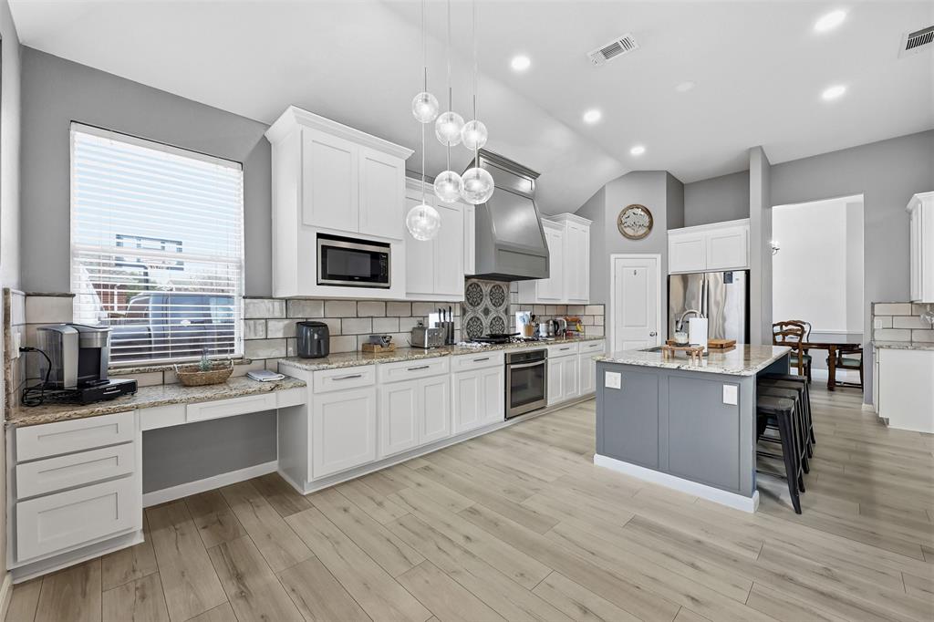 1801 Rim Rock Trail Mansfield, TX 76063 - Photo 7 of 40 a large kitchen with cabinets wooden floor and stainless steel appliances