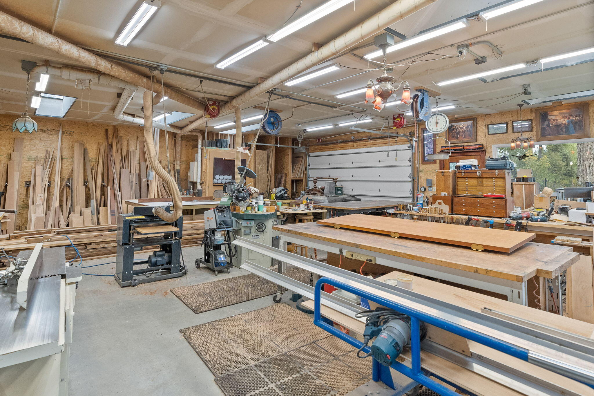 21925 Bear Creek Road Bend, OR 97702 - Photo 74 of 104 Inside Workshop has skylights, 2 walls of windows, potbellied stove and 2nd level storage