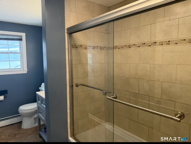 a bathroom with a toilet and a shower