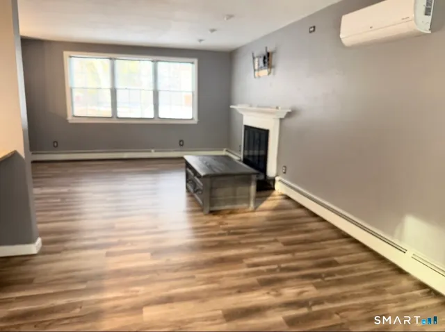 a room with wooden floor and fireplace
