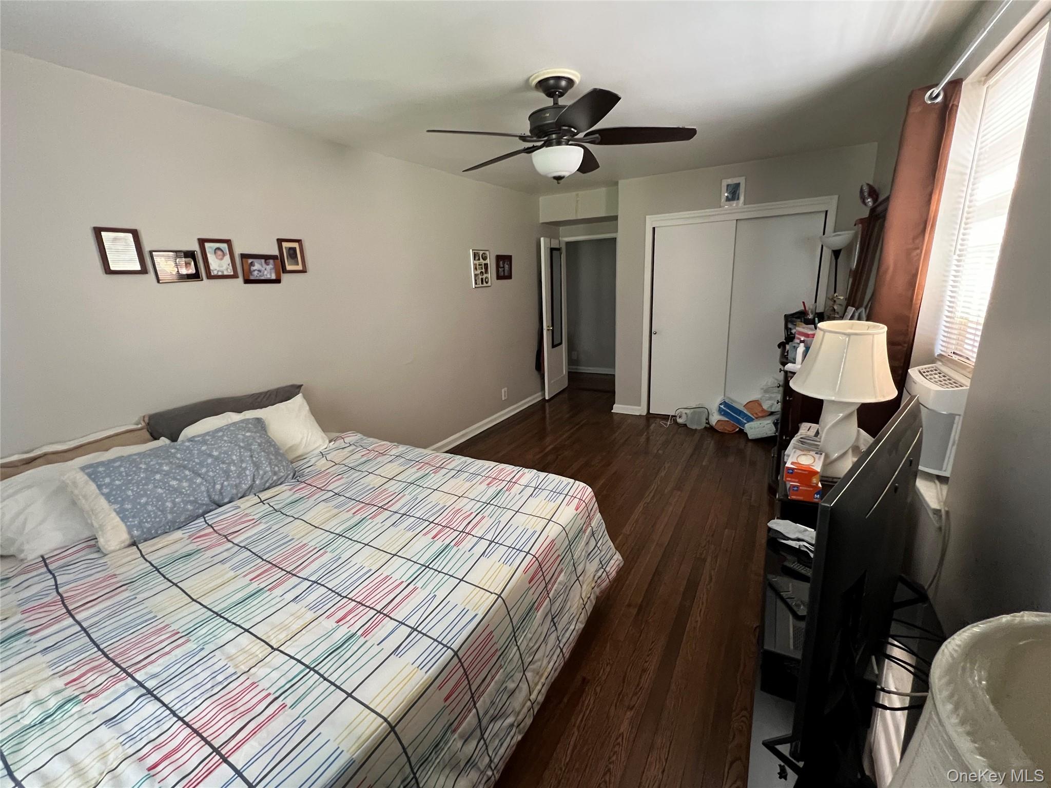 2080 Barnes Avenue, Unit 4C Bronx, NY 10462 - Photo 13 of 17 a bedroom with a bed and a chandelier