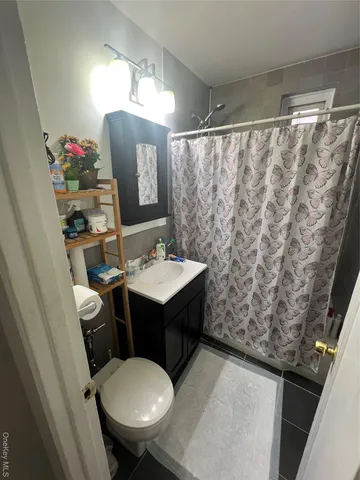 a bathroom with a sink vanity mirror and toilet