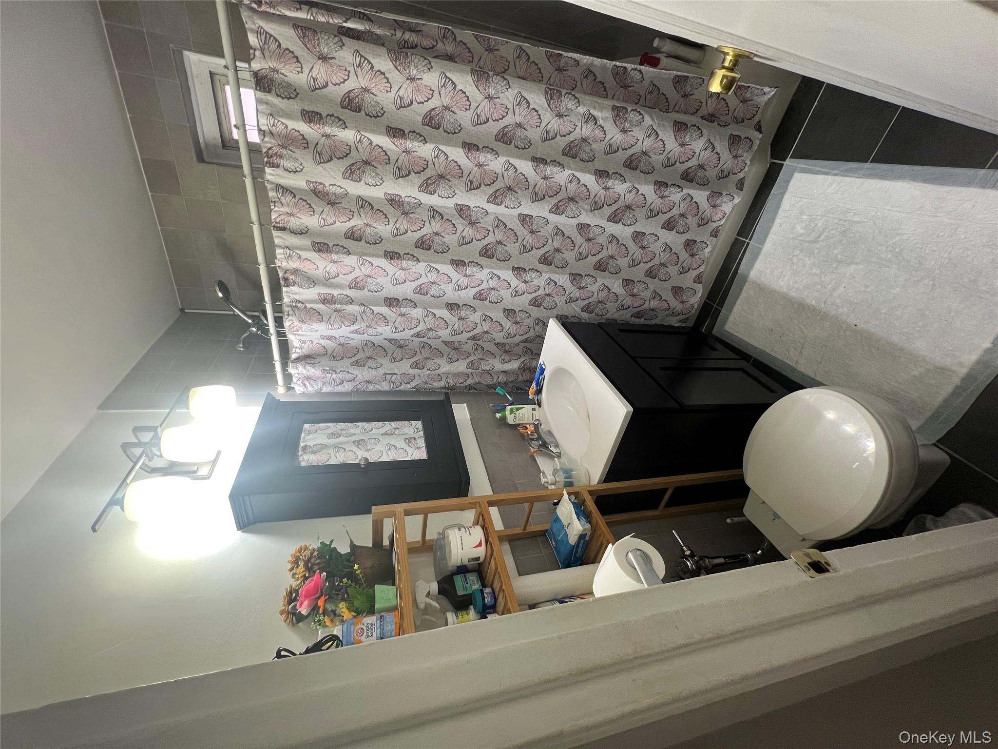 2080 Barnes Avenue, Unit 4C Bronx, NY 10462 - Photo 14 of 17 a bathroom with a sink vanity mirror and toilet