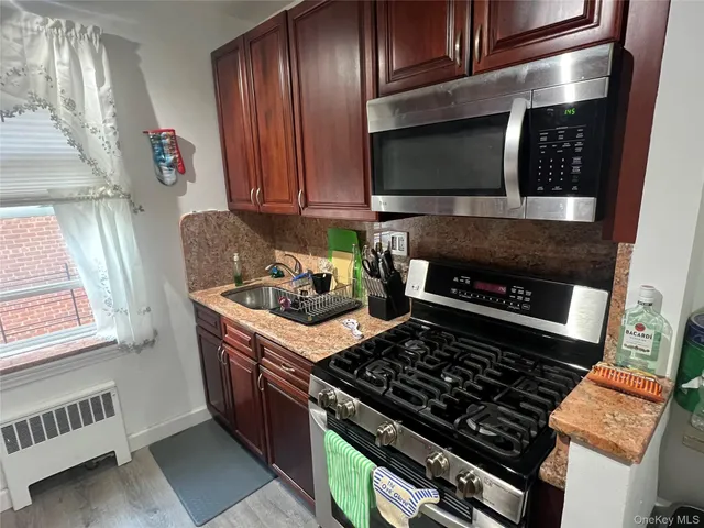 a kitchen with wooden cabinets and a stove top oven