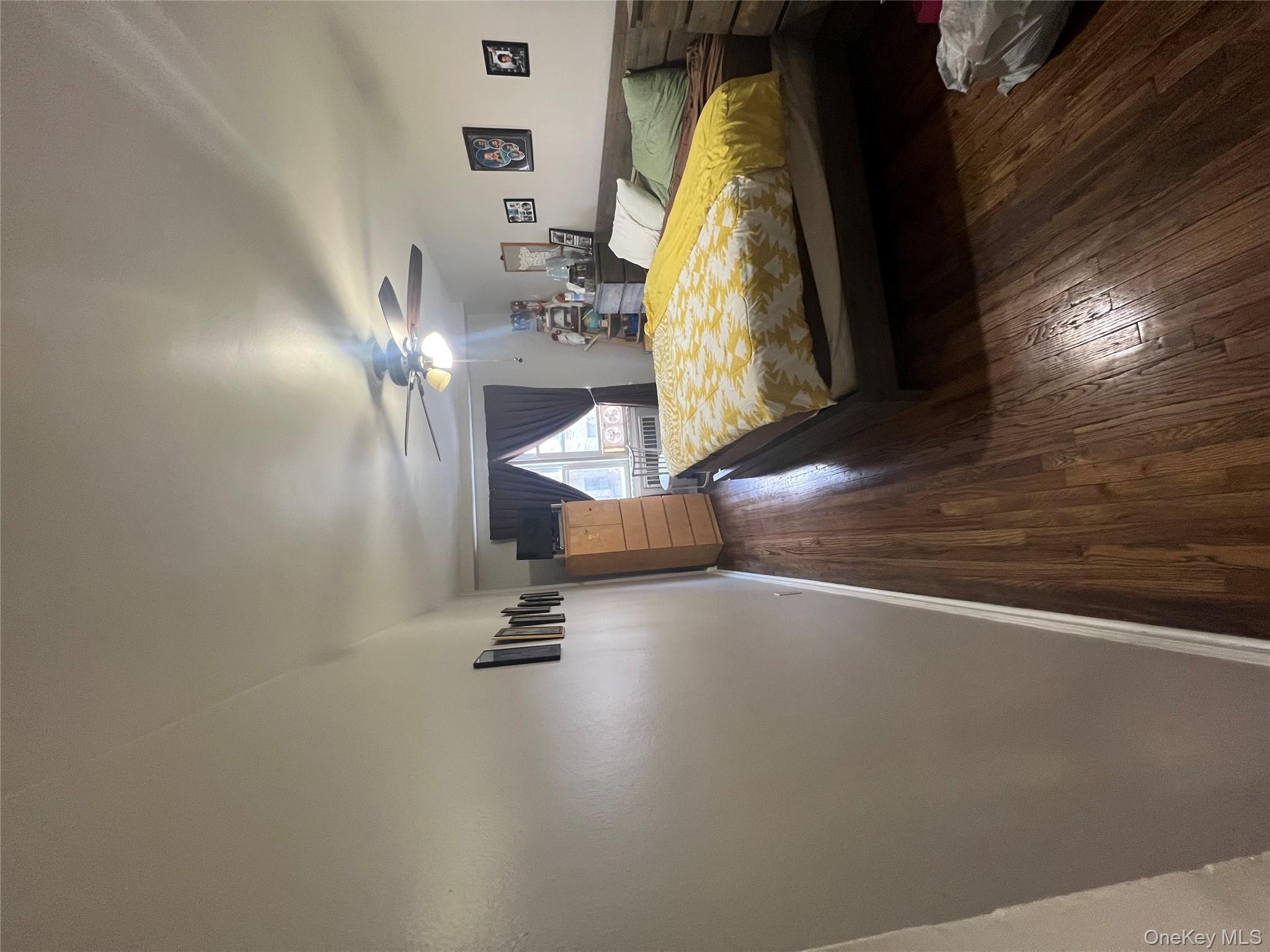 2080 Barnes Avenue, Unit 4C Bronx, NY 10462 - Photo 10 of 17 a bedroom with a bed and wooden floor