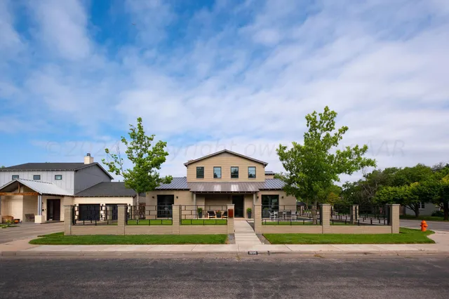 a front view of residential houses with yard and green space