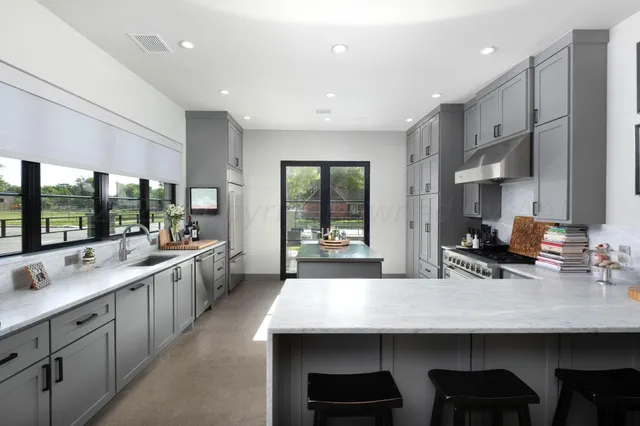 a kitchen with kitchen island a large window in it