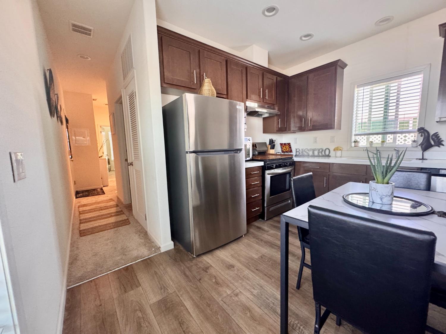 360 East Grant Line Road, Unit 16 Tracy, CA 95376 - Photo 4 of 36 Kitchen featuring wood-finish flooring and dark wood cabinetry