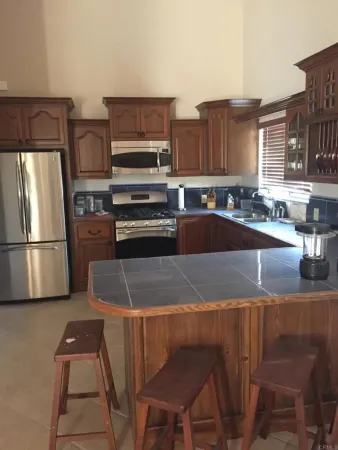 a kitchen with stainless steel appliances granite countertop a stove refrigerator and a sink
