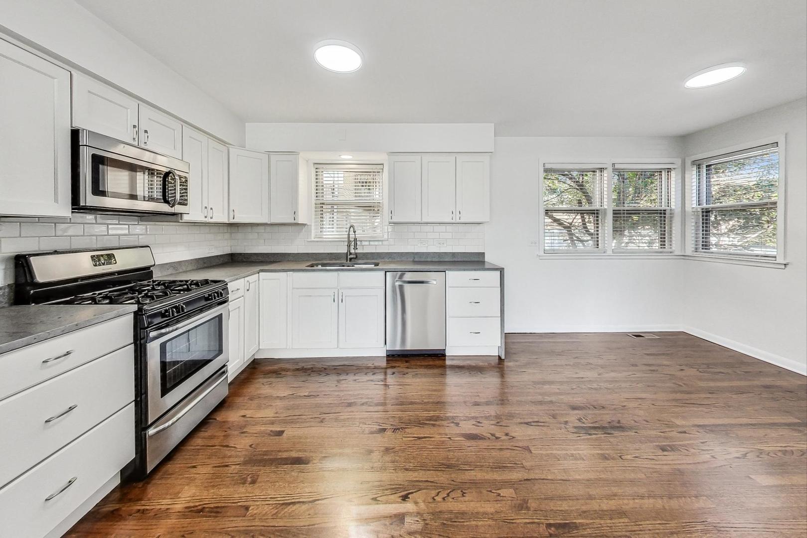1108 Fortuna Avenue, Unit 1 Park Ridge, IL 60068 - Photo 12 of 39 a kitchen with stainless steel appliances granite countertop a stove top oven a sink dishwasher and a refrigerator with wooden floor