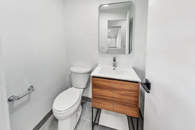 a bathroom with a toilet a sink and mirror