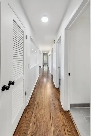 a view of a hallway with wooden floor and staircase