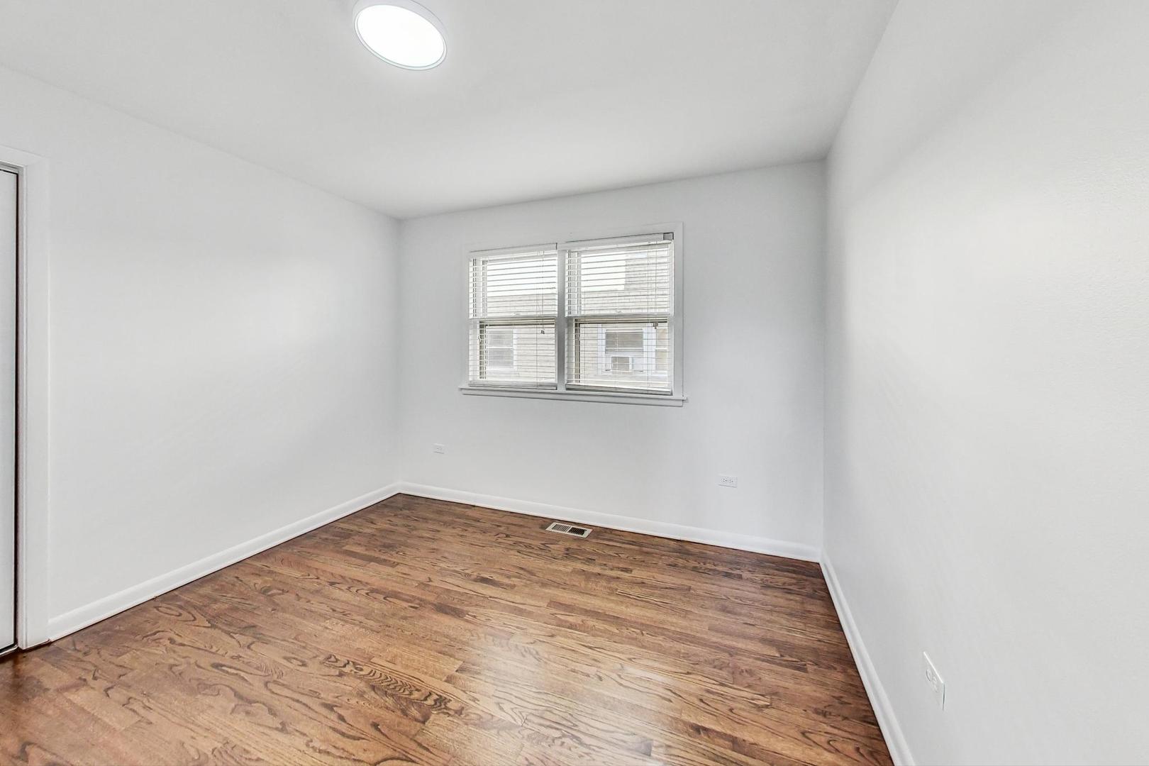 1108 Fortuna Avenue, Unit 1 Park Ridge, IL 60068 - Photo 32 of 39 an empty room with wooden floor and windows