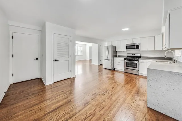a view of kitchen with wooden floor and electronic appliances