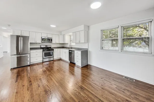 a kitchen with stainless steel appliances granite countertop a refrigerator microwave and stove top oven