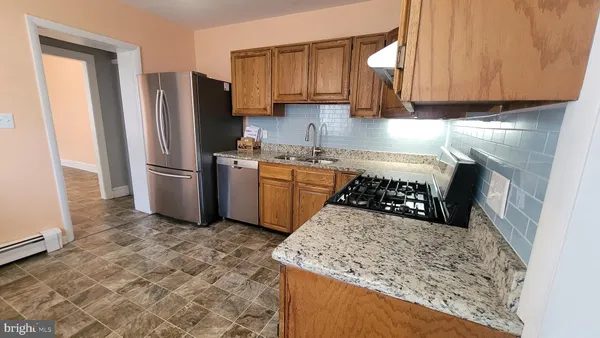 a kitchen with stainless steel appliances granite countertop a stove a refrigerator and a sink
