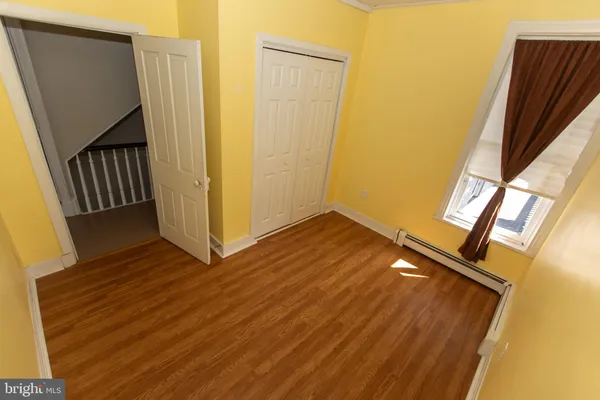 a view of an empty room with wooden floor