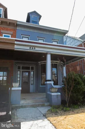 a front view of a house with potted plants