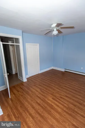 a view of empty room with wooden floor