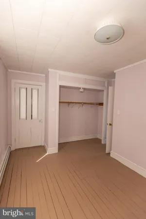 an empty room with wooden floor and cabinet