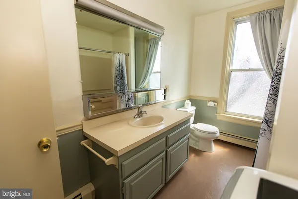 a bathroom with a sink toilet and mirror