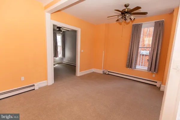 an empty room with windows and fan