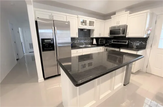 a kitchen with stainless steel appliances cabinets and a counter top space