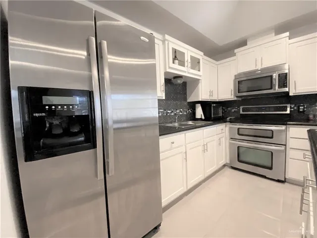 a kitchen with stainless steel appliances granite countertop a sink and a stove