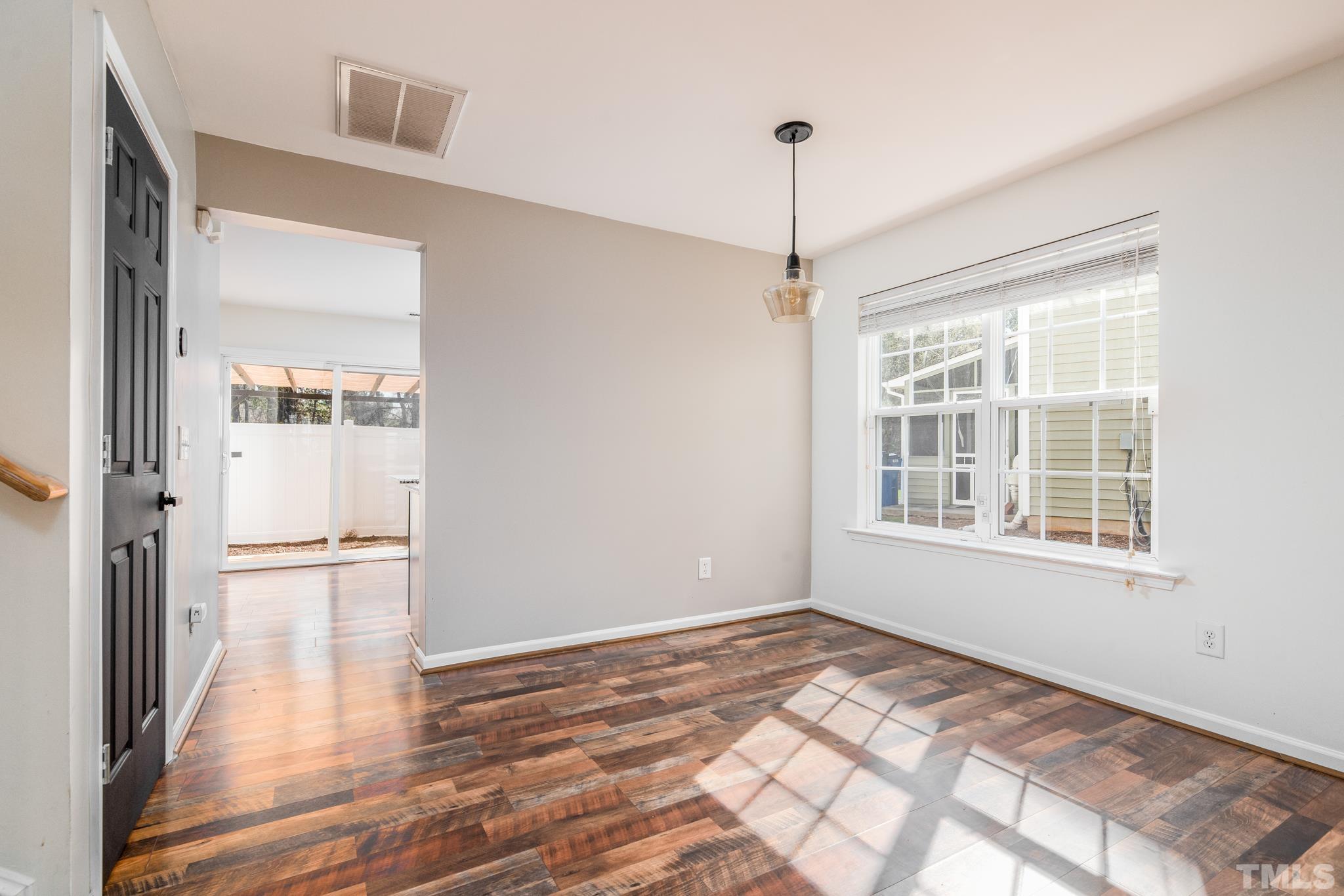 7814 Averette Field Drive Raleigh, NC 27616 - Photo 13 of 24 a view of an empty room with wooden floor and a window