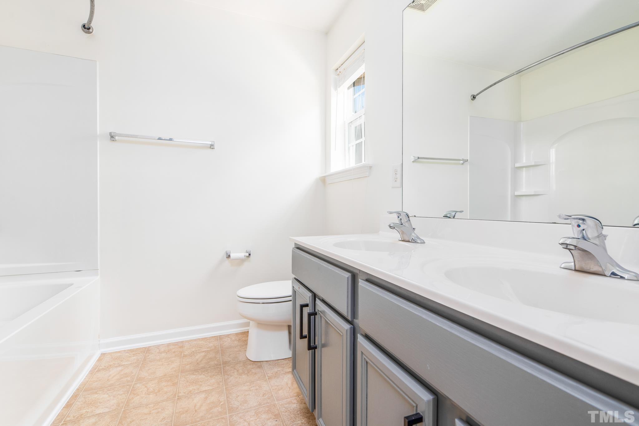 7814 Averette Field Drive Raleigh, NC 27616 - Photo 17 of 24 a bathroom with a sink a toilet and a mirror